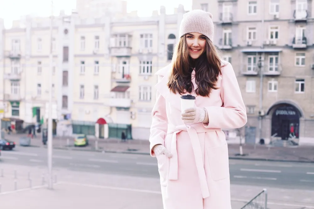 žena v ružovom kabáte v zime vonku na ulici