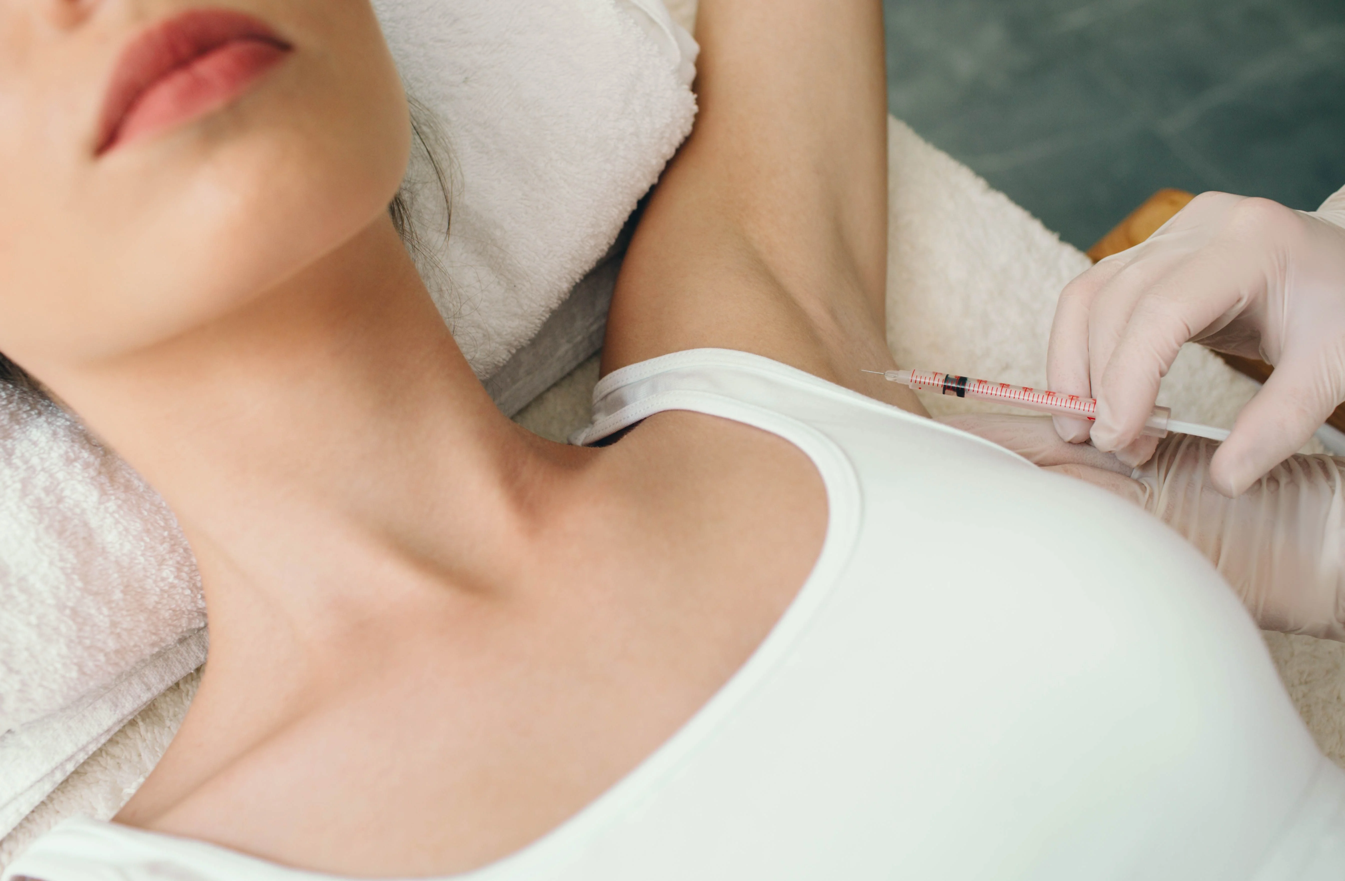 Na obrázku je žena ktorej do pazuchy pichajú botox Na obrázku je žena ktorej do pazuchy pichajú botox