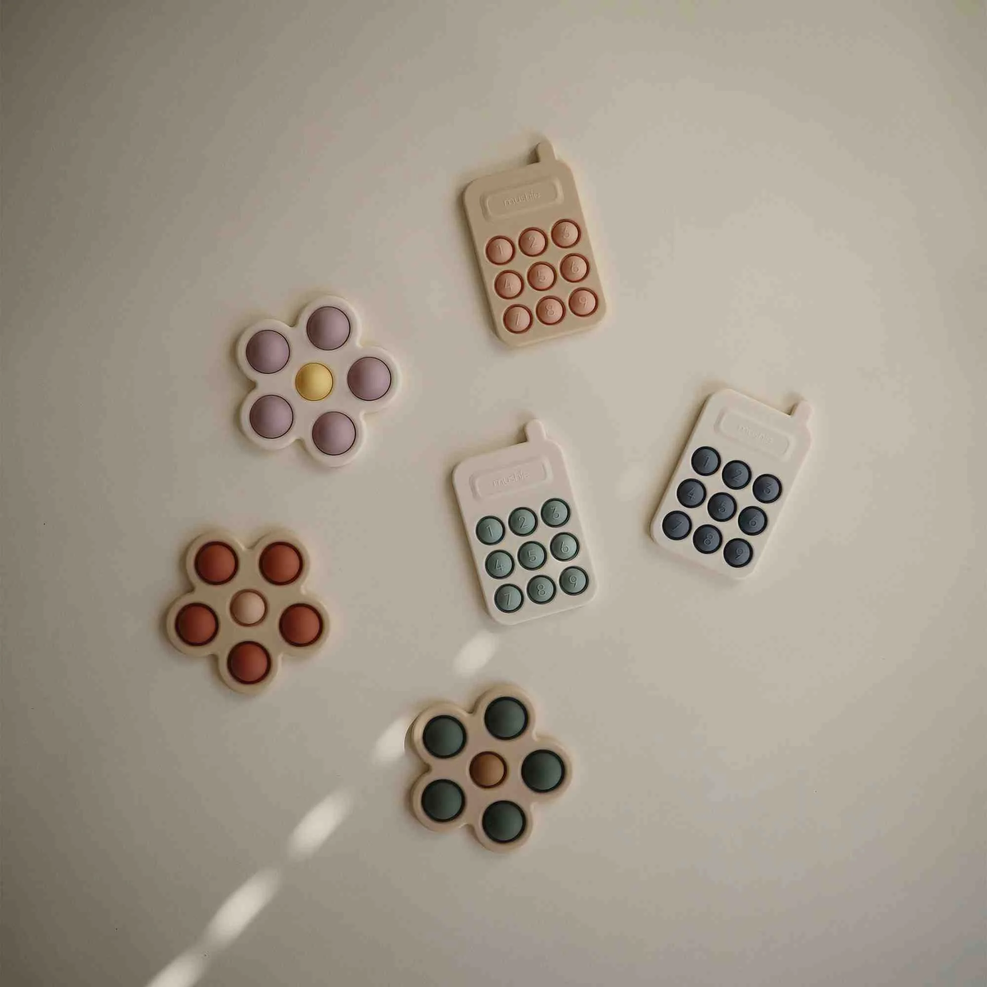 Mushie silikónová hračka pop-it Phone, Blush 1×1 ks, silikónová hračka